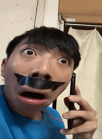 a man with duct tape on his mouth is talking on a phone