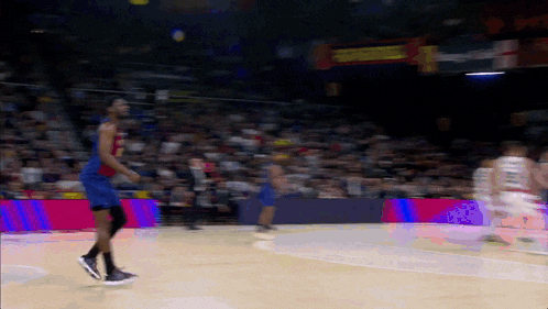 a basketball game is being played in front of a crowd with a sign that says ' nba ' on it