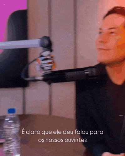 a man sitting in front of a microphone with the words e claro que ele deu falou