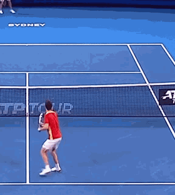 a tennis player is about to hit the ball on a court with sydney written on the floor