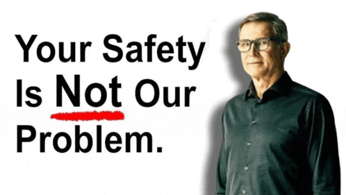 a man in a black shirt stands in front of a sign that says your safety is not our problem