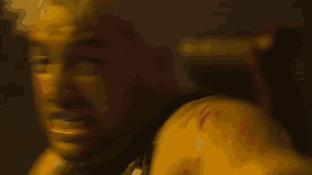 a blurry picture of a man 's face with a yellow shoulder