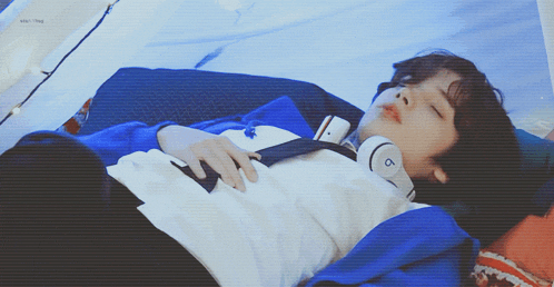 a person wearing a pair of beats headphones laying on a bed