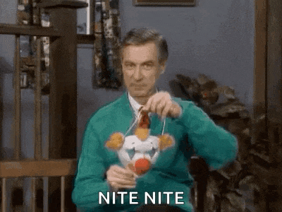 a man in a green sweater is sitting in a chair holding a stuffed clown and saying nite nite .