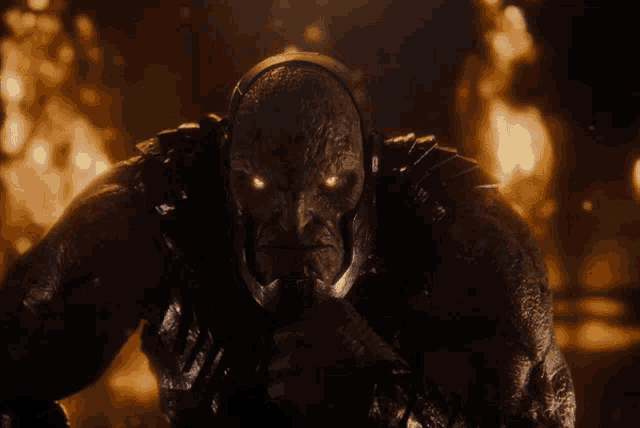 a monster with glowing red eyes looks at the camera