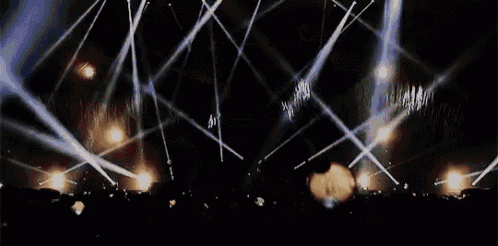 a crowd of people watching a concert with a lot of lights coming out of the stage .