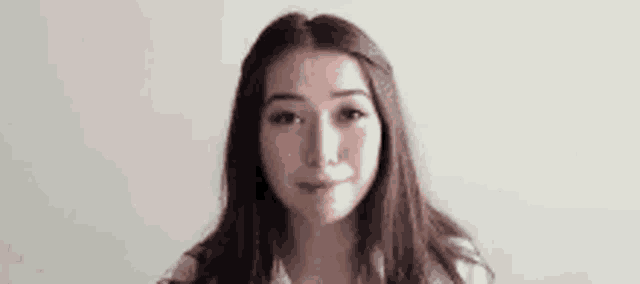 a young woman is smiling and looking at the camera .