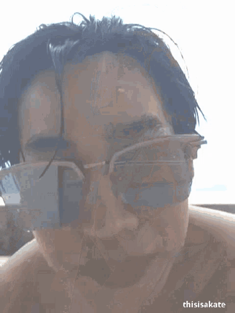 a close up of a person wearing sunglasses with their finger on their nose .