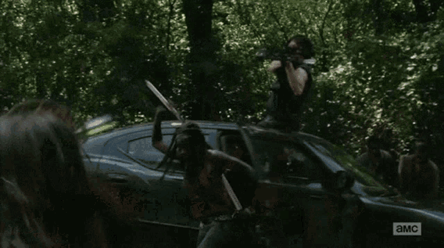 a man holding a sword in front of a car that says ' a.m.c ' on it