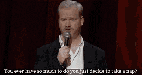 a man in a suit is holding a microphone and talking into it on a stage .