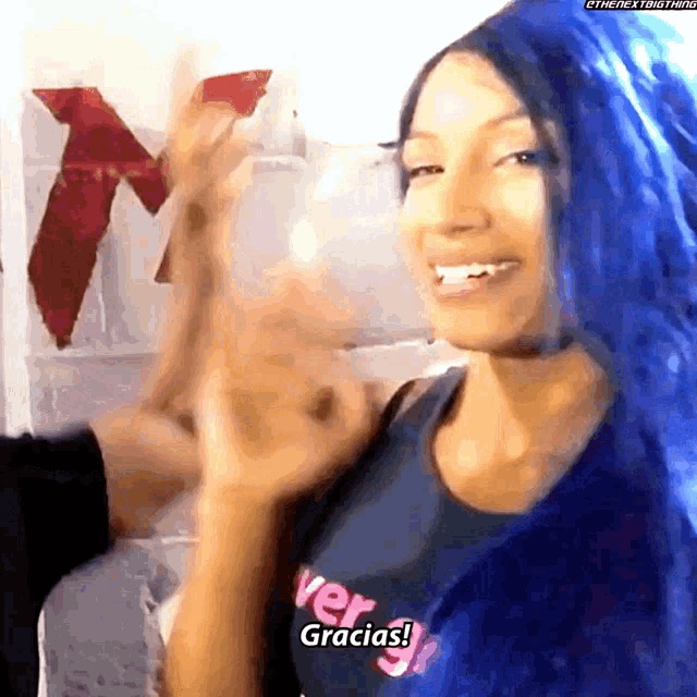 a woman with blue hair and a shirt that says ver gracias
