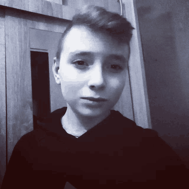 a black and white photo of a young boy with a shaved head
