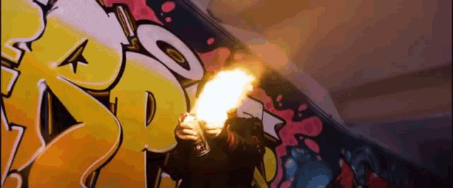 a person is holding a torch in front of a wall with graffiti on it that says r.o.