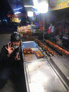 a man wearing a mask stands in front of a display of food