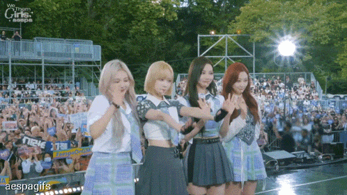 a group of girls are standing on a stage in front of a crowd with a sign that says " we them girls "