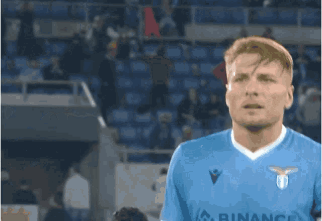 a soccer player wearing a blue jersey with the word binance on it