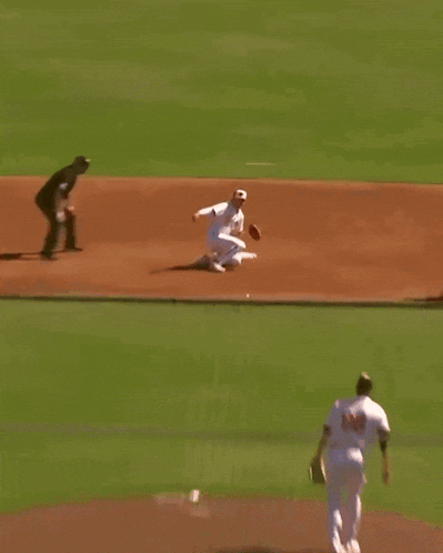a baseball player wearing a red shirt with the word angels on it is trying to catch a ball