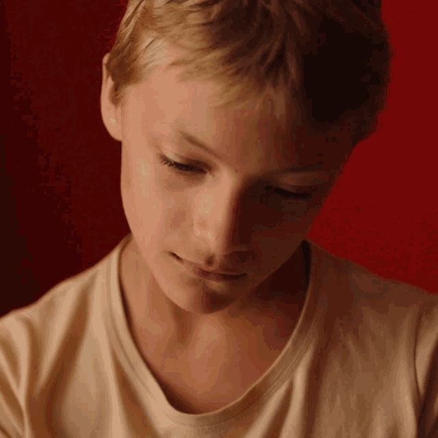 a close up of a boy 's face with a red background