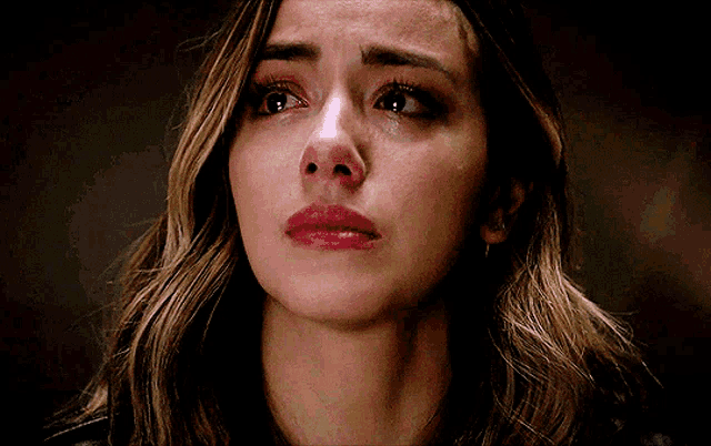 a close up of a woman 's face with tears coming out of her eyes