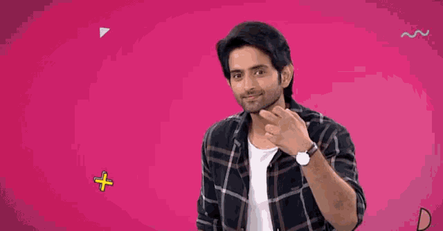 a man in a plaid shirt is smiling in front of a pink background with the words thank you