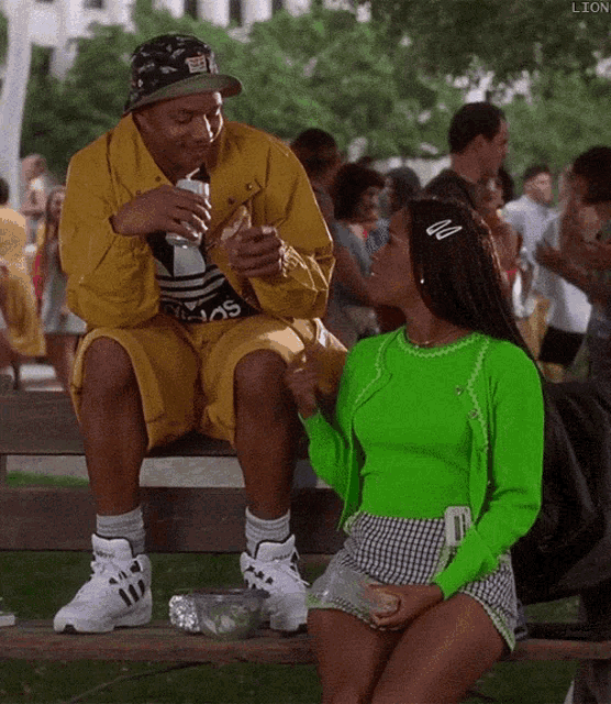 a man and a woman are sitting on a bench and the woman is wearing a neon green outfit