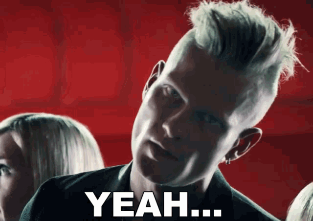 a man with a mohawk says yeah in front of a crowd