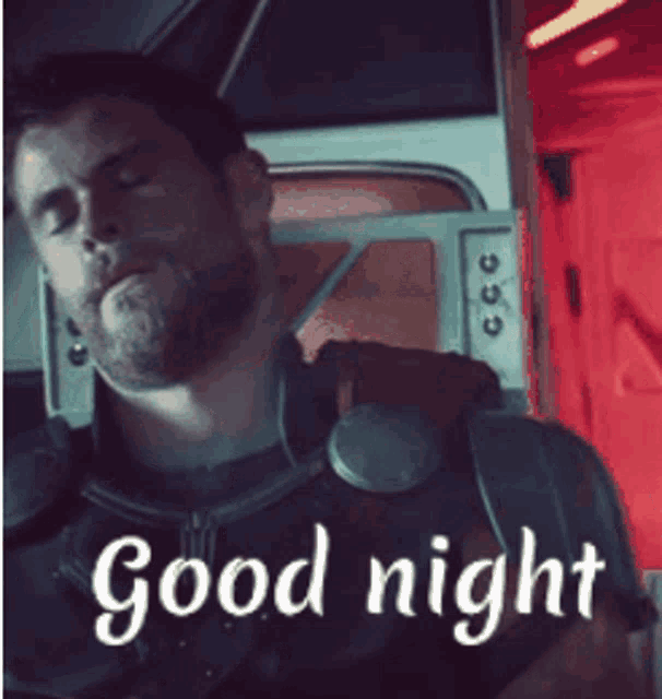 a man with a beard is sleeping in a room with the words good night written above him .