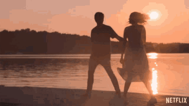 a silhouette of a man and a woman dancing on a beach with netflix written on the bottom
