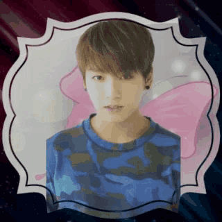 a picture of a boy in a blue shirt with a pink butterfly on his shoulder