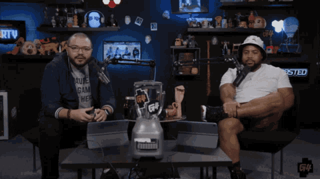 two men are sitting in front of a microphone and a blender that says g14 on it