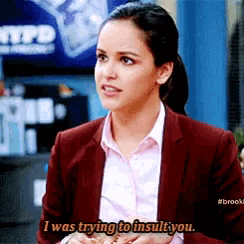 a woman in a suit and white shirt is saying i was trying to insult you .