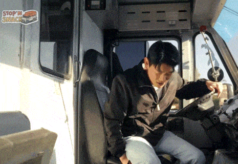 a man sits in the driver 's seat of a stop 'n shack
