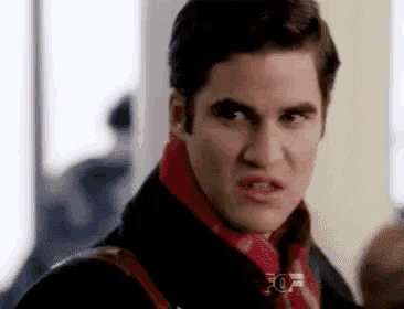 a close up of a man wearing a red scarf and a black jacket .