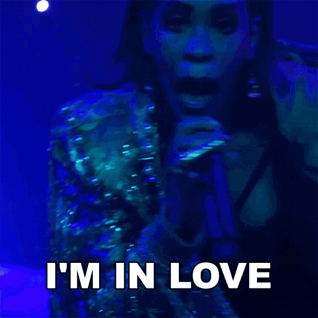 a woman singing into a microphone with the words " i 'm in love " on the bottom