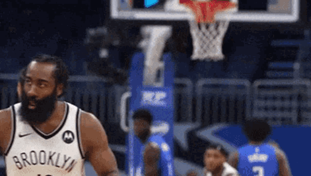 a man in a brooklyn jersey is playing basketball .