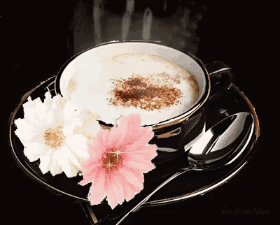 a cup of coffee on a saucer with flowers and a silver spoon