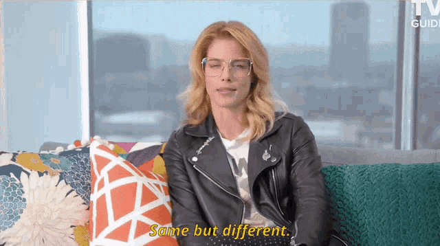 a woman wearing glasses and a leather jacket is sitting on a couch and saying same but different