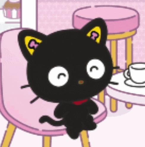 a black cat with a yellow ear sits on a pink chair next to a cup of coffee