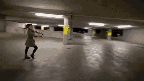 a woman is playing a violin in a garage