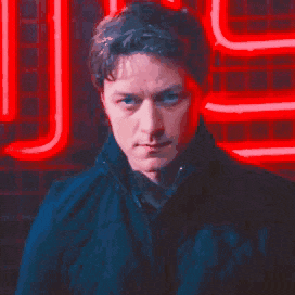 a man is standing in front of a neon sign that says j.