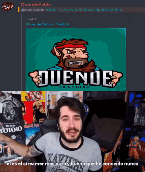 a man with a beard is standing in front of a duende logo
