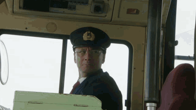 a man wearing a hat and glasses is sitting in a car