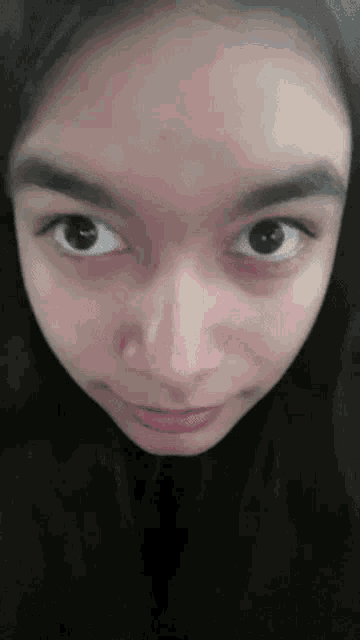 a close up of a woman 's face with a slight smile on her face
