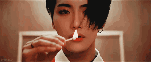 a close up of a person lighting a match with the word yeosanz on the bottom