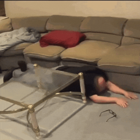 a man is laying on the floor under a glass table