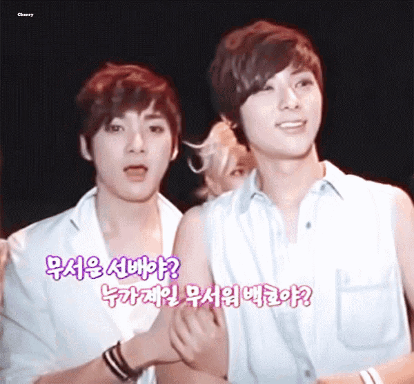 two young men are standing next to each other and one of them is wearing a white shirt that says cherry on it