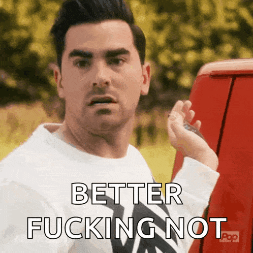 a man standing next to a red van with the words better fucking not written on it