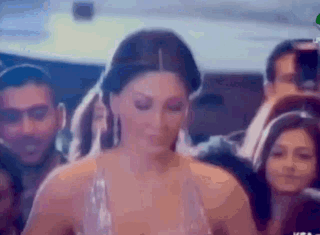 a woman is walking through a crowd of people .