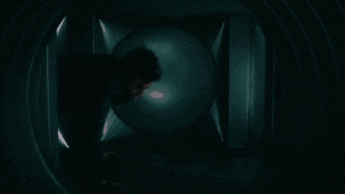 a person standing in a dark room with a light coming out of the corner
