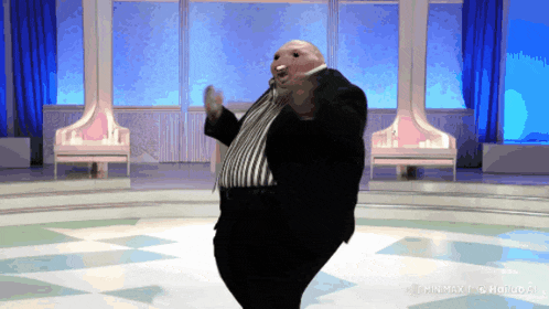 a fat man in a suit is dancing on a stage with a watermark that says mmmax
